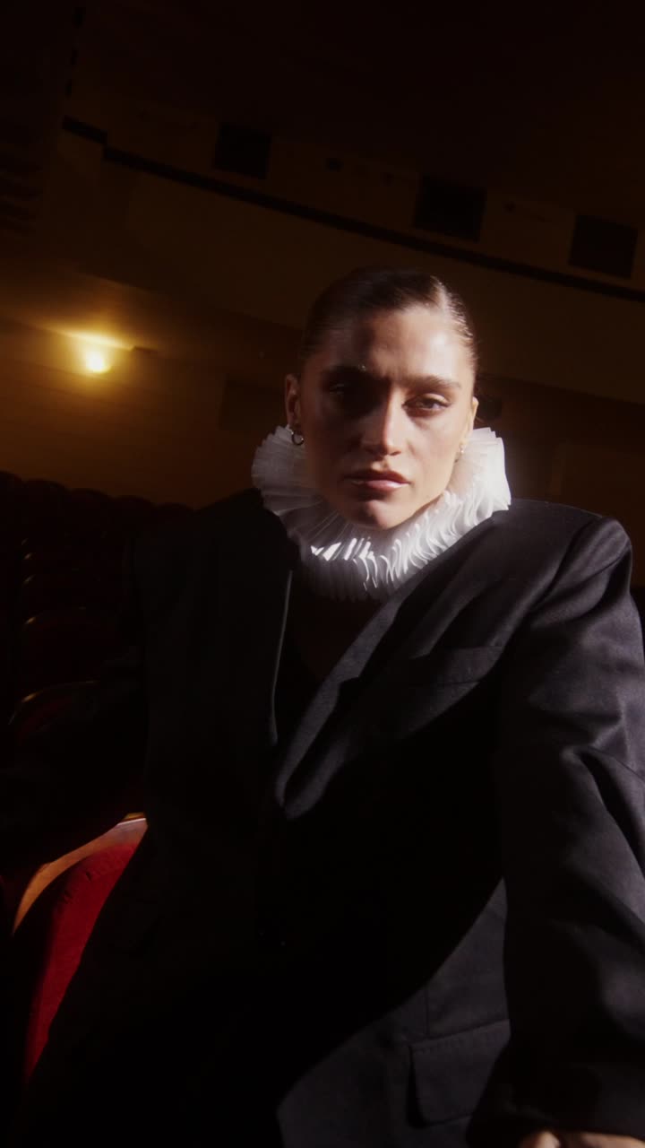 Mulher com traje de inspiração histórica em um teatro