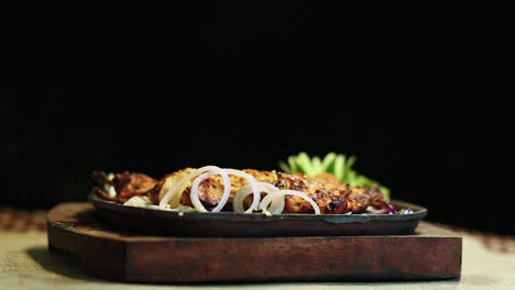 close-up roasted chicken bbq sprinkle with salt male hand black background