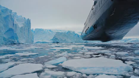a ship navigating icy waters past massive icebergs in antarctica