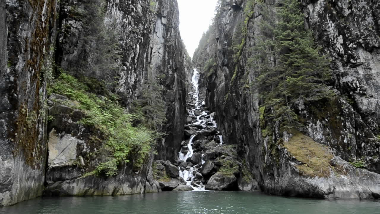 paseo en bote pov entrando en un abismo muy empinado con cascada en los fiordos en vados terror en tracy armfords terror desierto área sureste de alaska