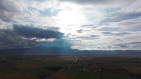 panning drone shot of a country road going through rural farm land in idaho