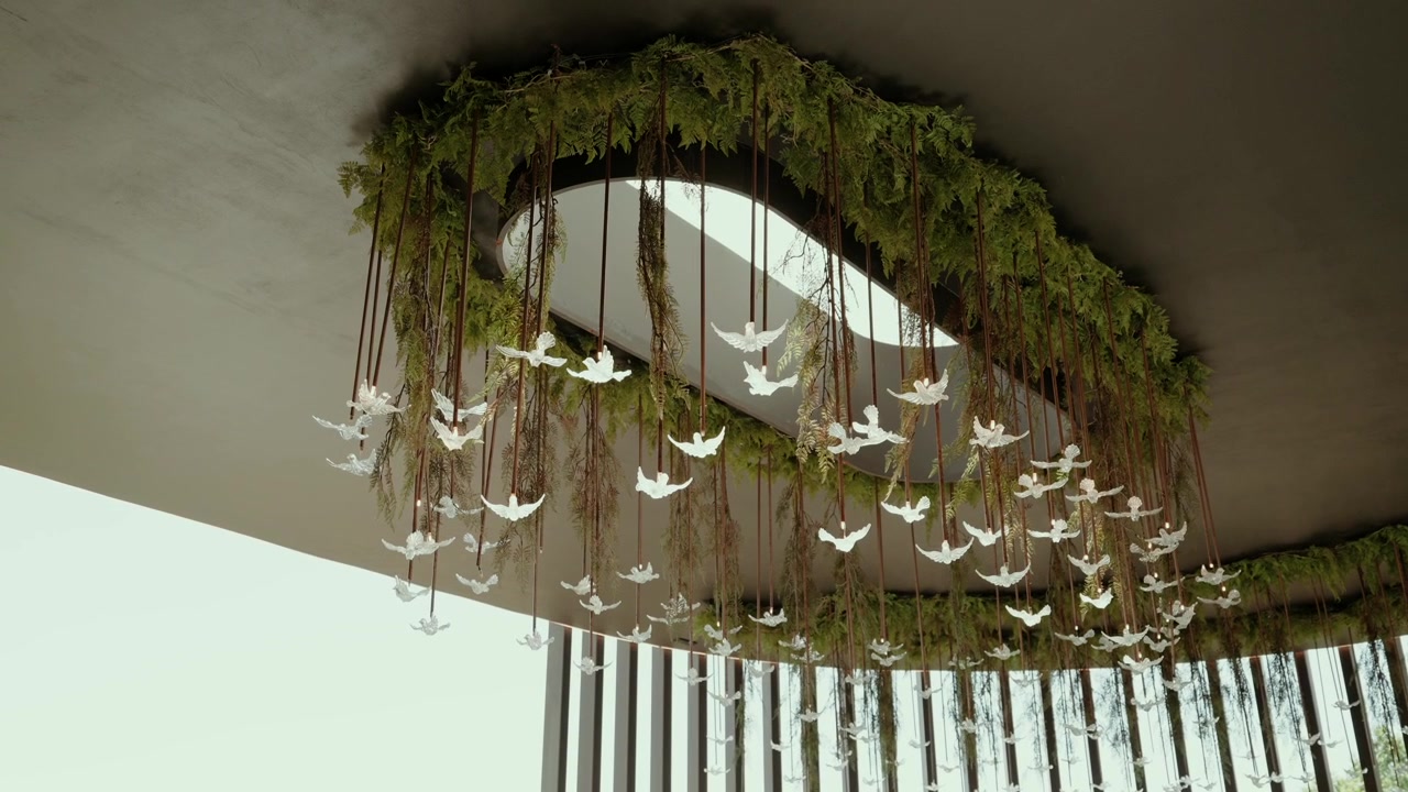 Bregner og grønne planter omkring en loftåbning med dusinvis af glasfuglelamper over en udendørs terrasse