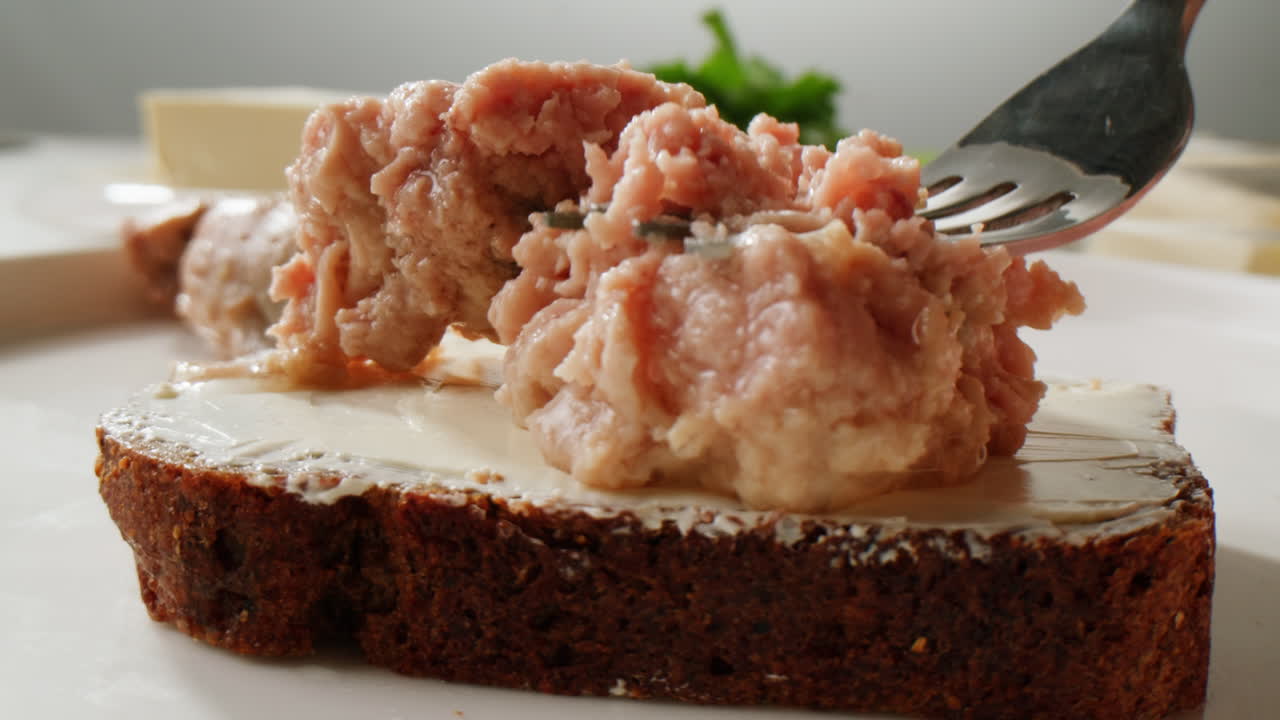 Smoked cod liver in oil in open tin can with fresh greens on wooden table. Seafoods delicacy. High quality 4k footage