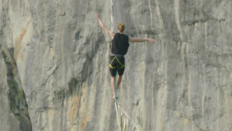 athlete on high line slack line over cliff in germany