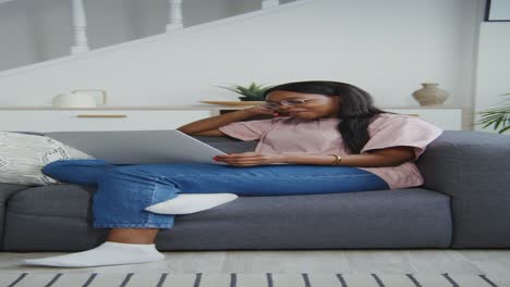 woman using laptop on couch