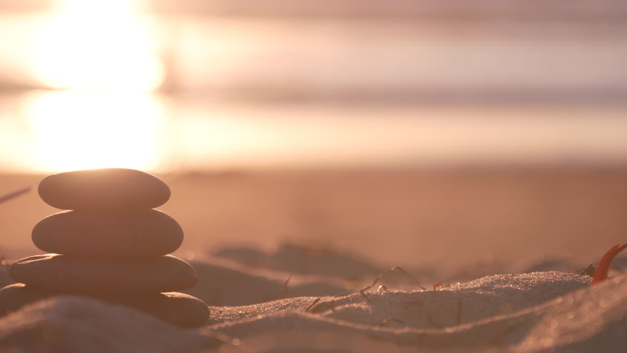 자갈 돌 어리, 모래 바다 해변, 해가 지는 하늘, 물에 의해 균형 잡힌 바위.