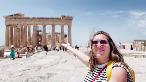 happy vlogger presenting the parthenon to the camera, athens, greece
