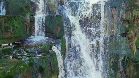 Aerial-drone-footage-of-a-tall-rocky-waterfall-in-the-Yorkshire-Dales,-Pennies