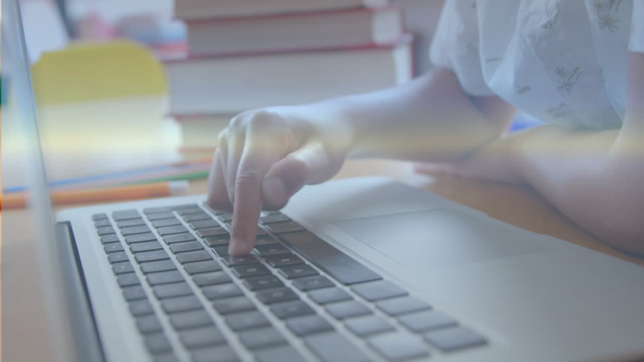 Child pressing laptop keys and generating holographic charts and globe icons for education