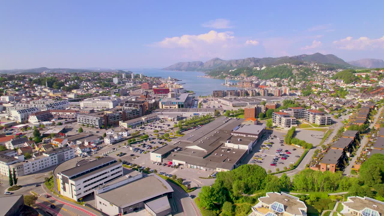 푸른 물, 산과 멋진 건물로 가득 찬 피오르드의 끝에 있는 도시의 드론 영상을 올리십시오.