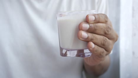 mano con un vaso de leche