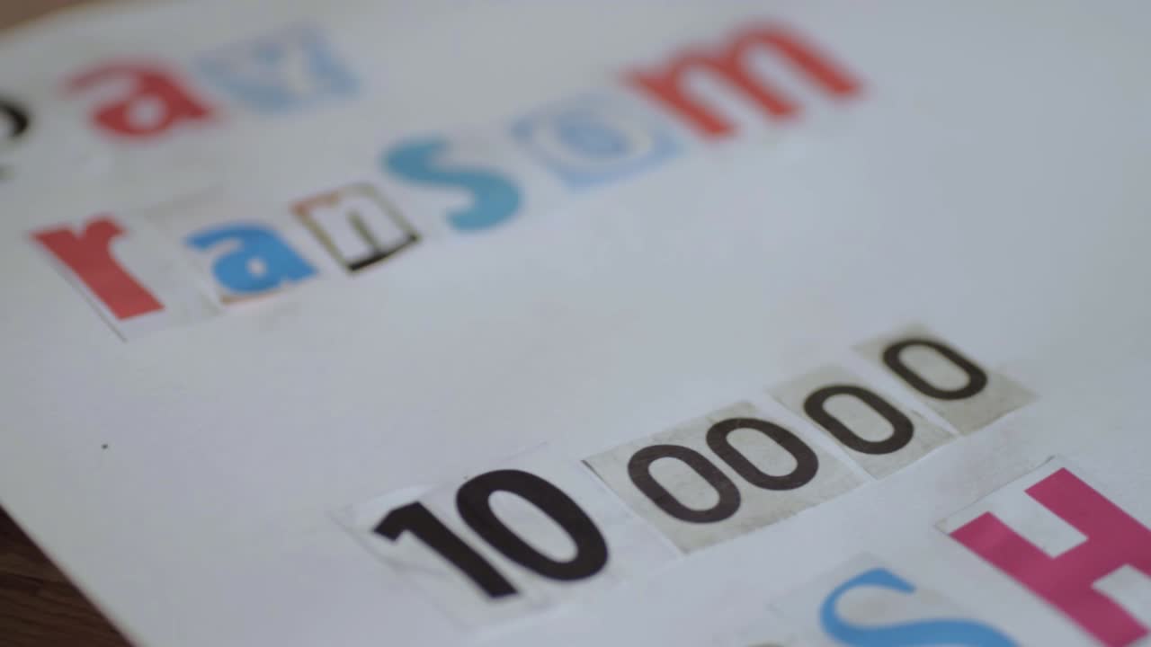 Kidnap ransom note in cut out letters demanding cash panning shot