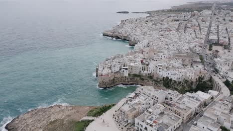 rotating aerial footage of the town of polignano a mare during a stormy day in italy