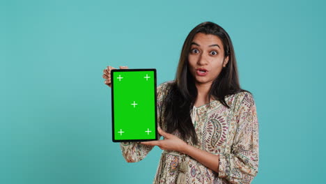 retrato de una mujer haciendo marketing de influencia usando una tableta de pantalla verde