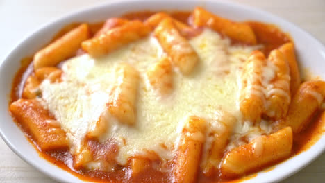 pastel de arroz coreano en salsa coreana picante con queso, tokpokki de queso, tteokbokki con queso - estilo de comida coreana
