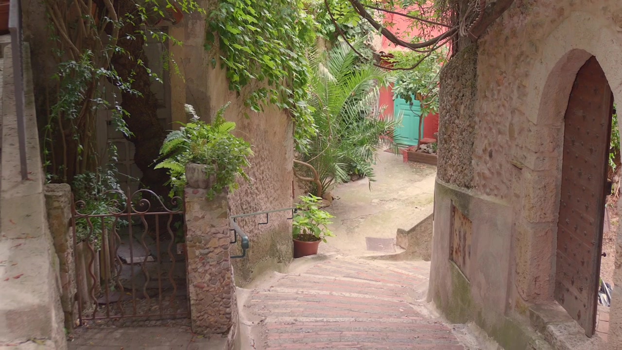 Bellissimo vicolo dal sapore antico con muri in pietra e vegetazione in un borgo medievale, Roquebrune Cap Martin, Francia