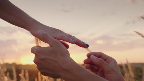 man placing engagement ring on finger in slow motion