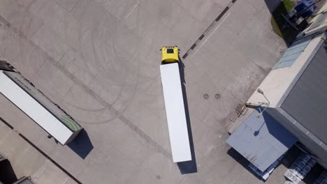 Aerial view of a yellow truck and trailer in a parking lot