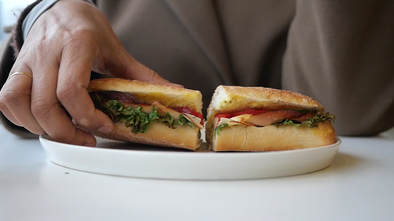 Mano che prende un panino fresco da un piatto