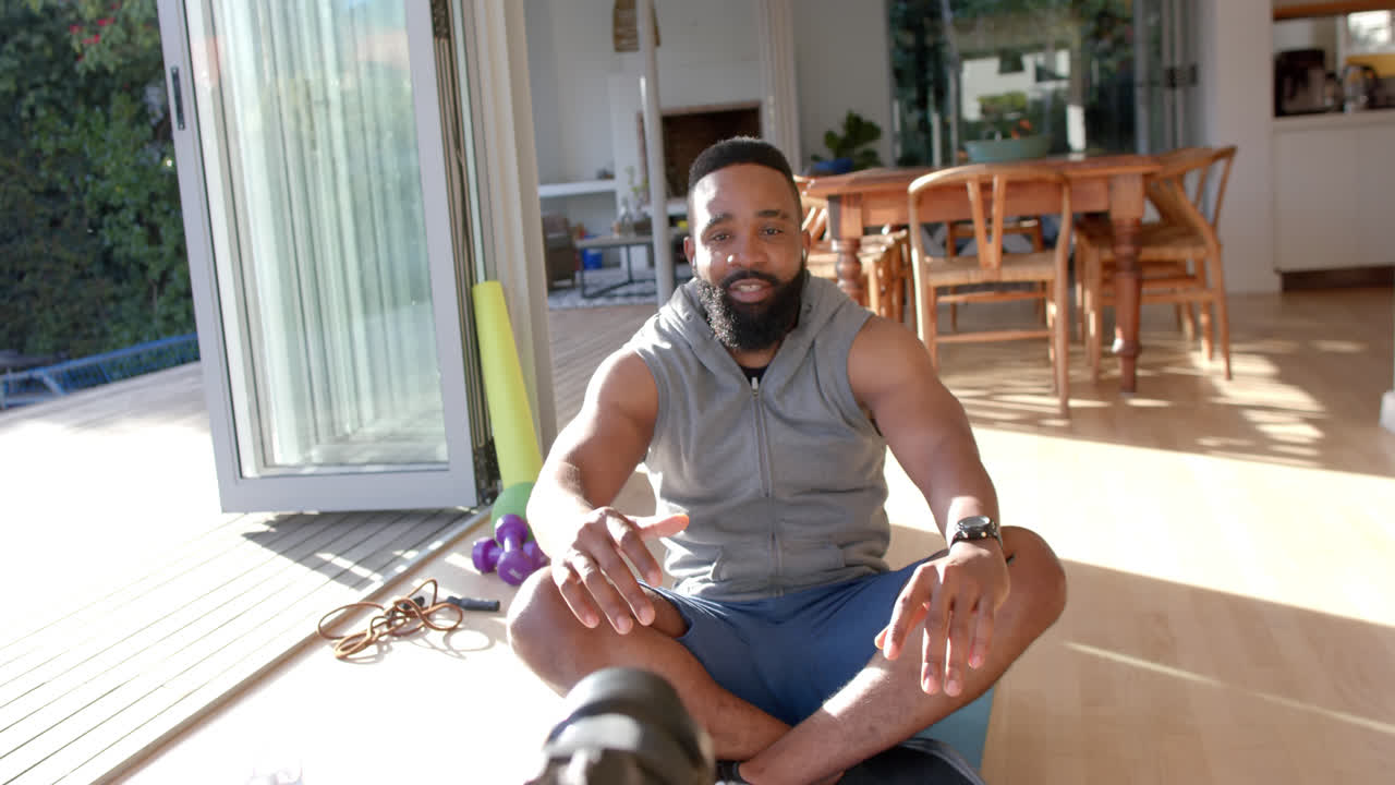 vlogger de fitness afroamericano aconsejando y filmando en casa, cámara lenta