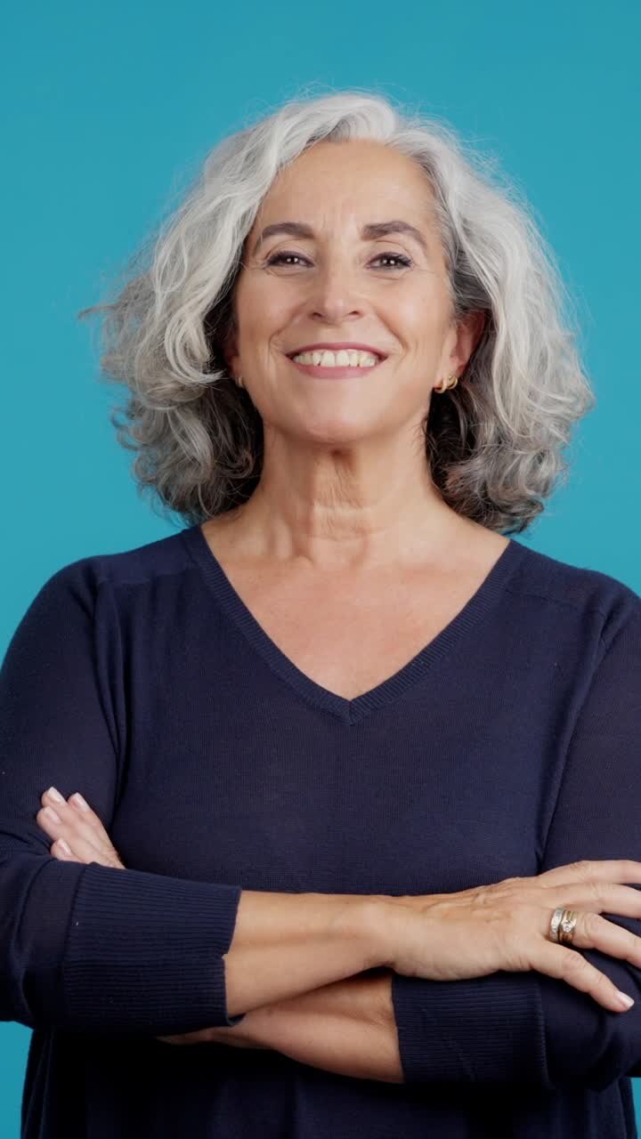Smiling senior woman with gray hair and crossed arms