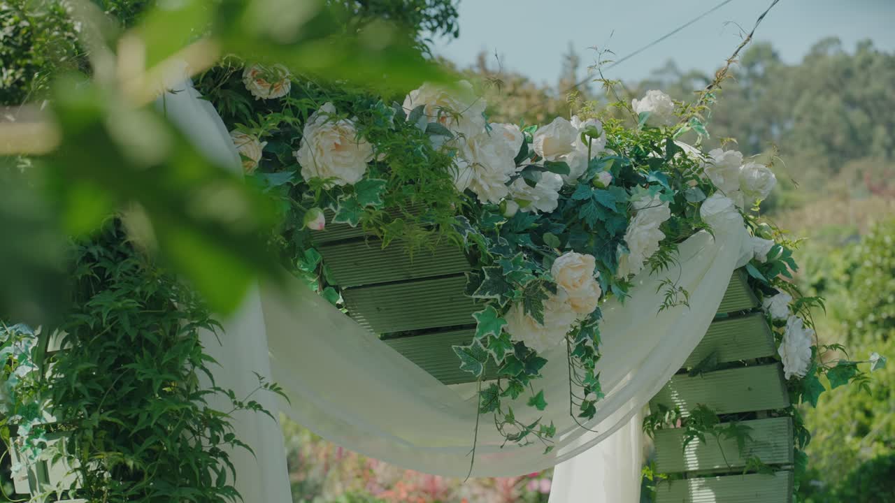 Close up of floral wedding arch with white roses and greenery
