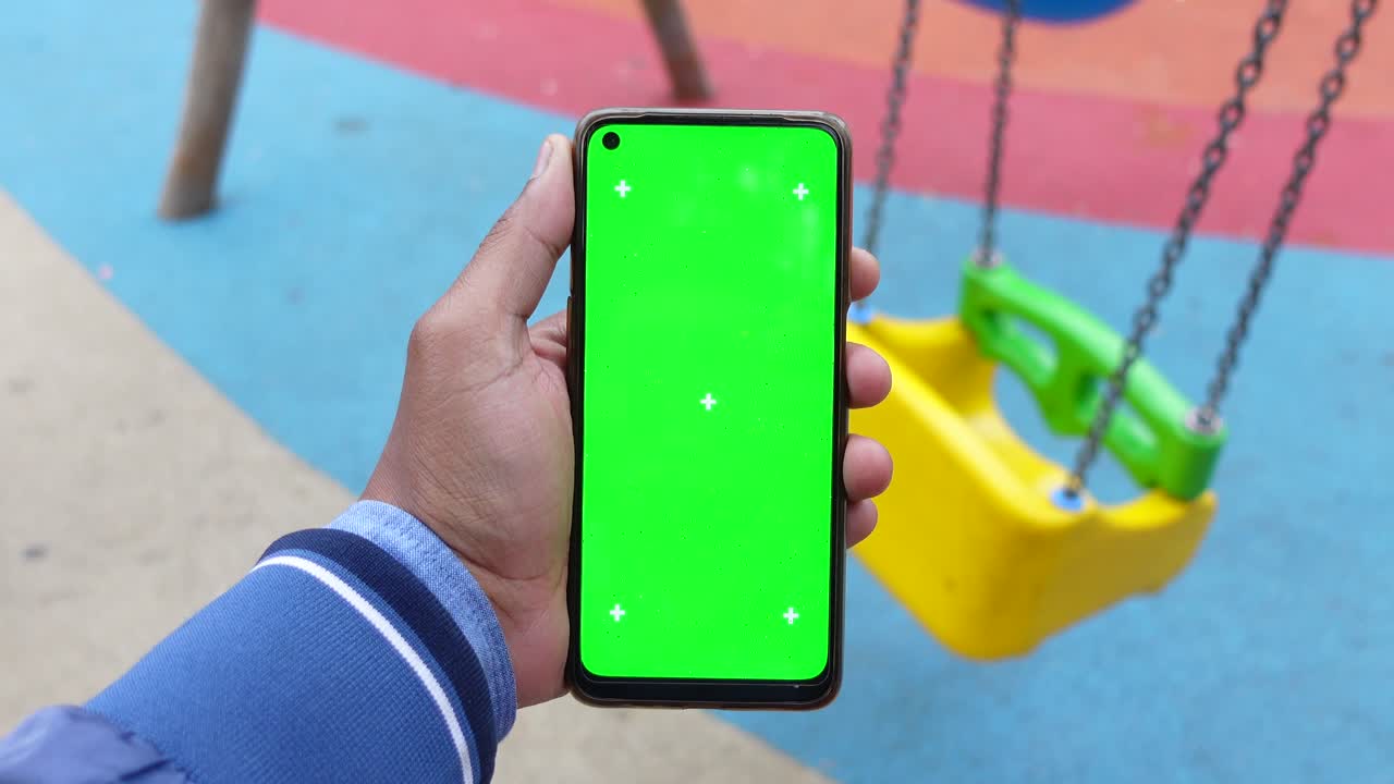 pantalla verde de teléfono inteligente en el patio de recreo