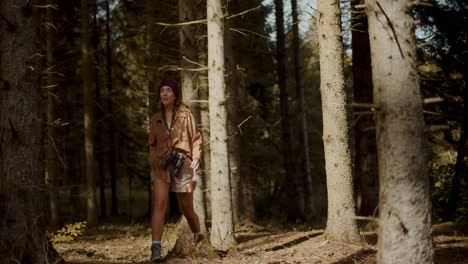 turista femenina con binoculares explorando en el bosque