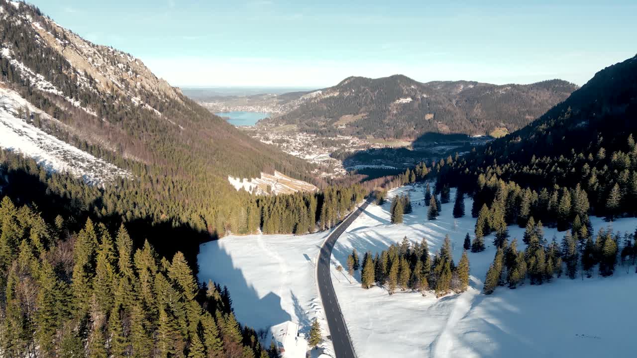 impresionante vista aérea desde un avión no tripulado: paso de montaña cubierto de nieve, vista panorámica del schliersee en alemania, paisaje de los alpes bávaros con carretera y lago de montaña lejano en la temporada de invierno