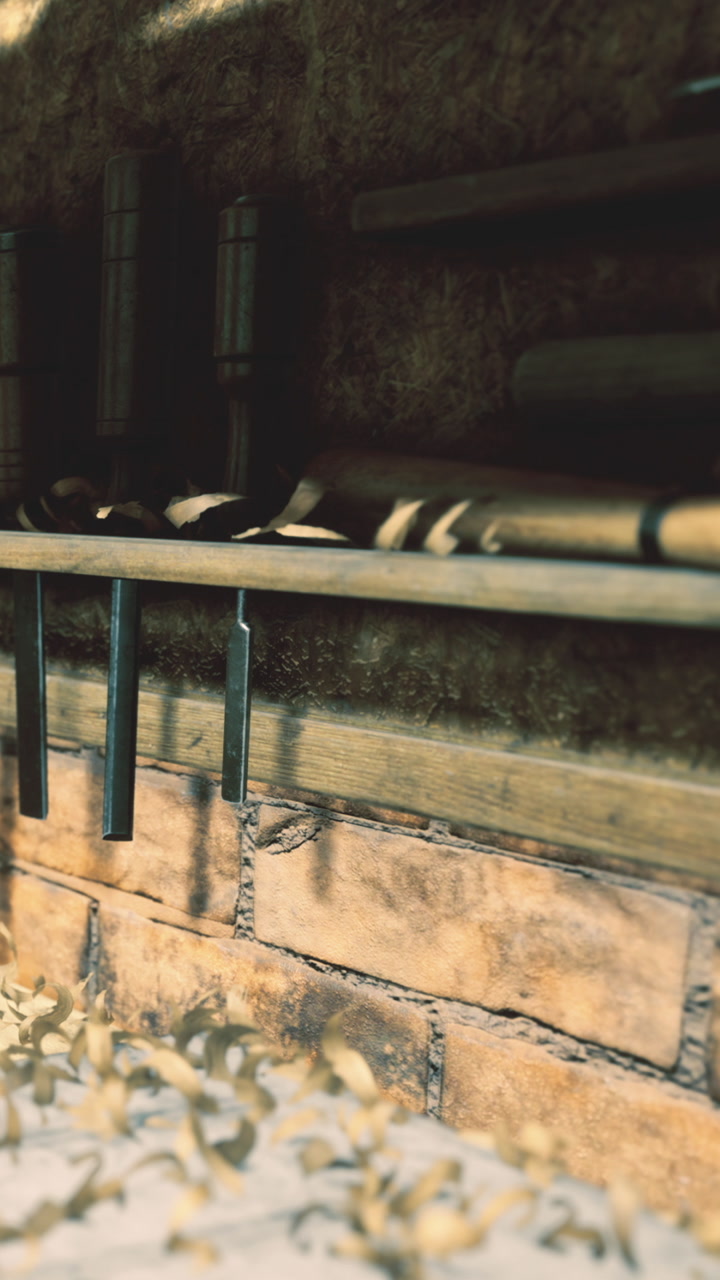 Rustic tools hang in sunlight casting shadows on weathered stone wall