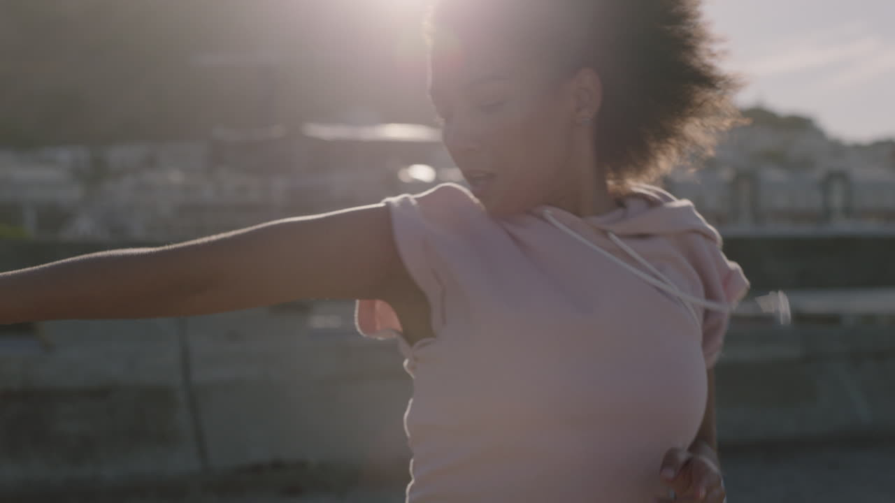 mujer bailarina joven y hermosa bailarina de calle con afro realizando movimientos contemporáneos disfrutando del baile freestyle urbano en la ciudad de cerca