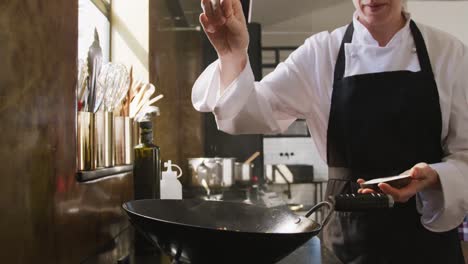 chef adding salt on the vegetables