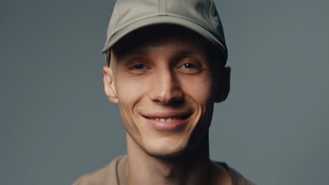 portrait of a young man smiling and wearing a baseball cap