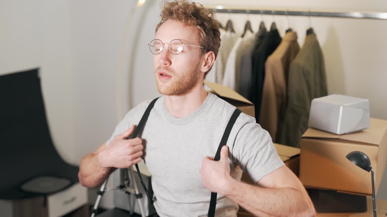 귀여운 곱슬머리 남자가 안경을 쓰고 웃는다