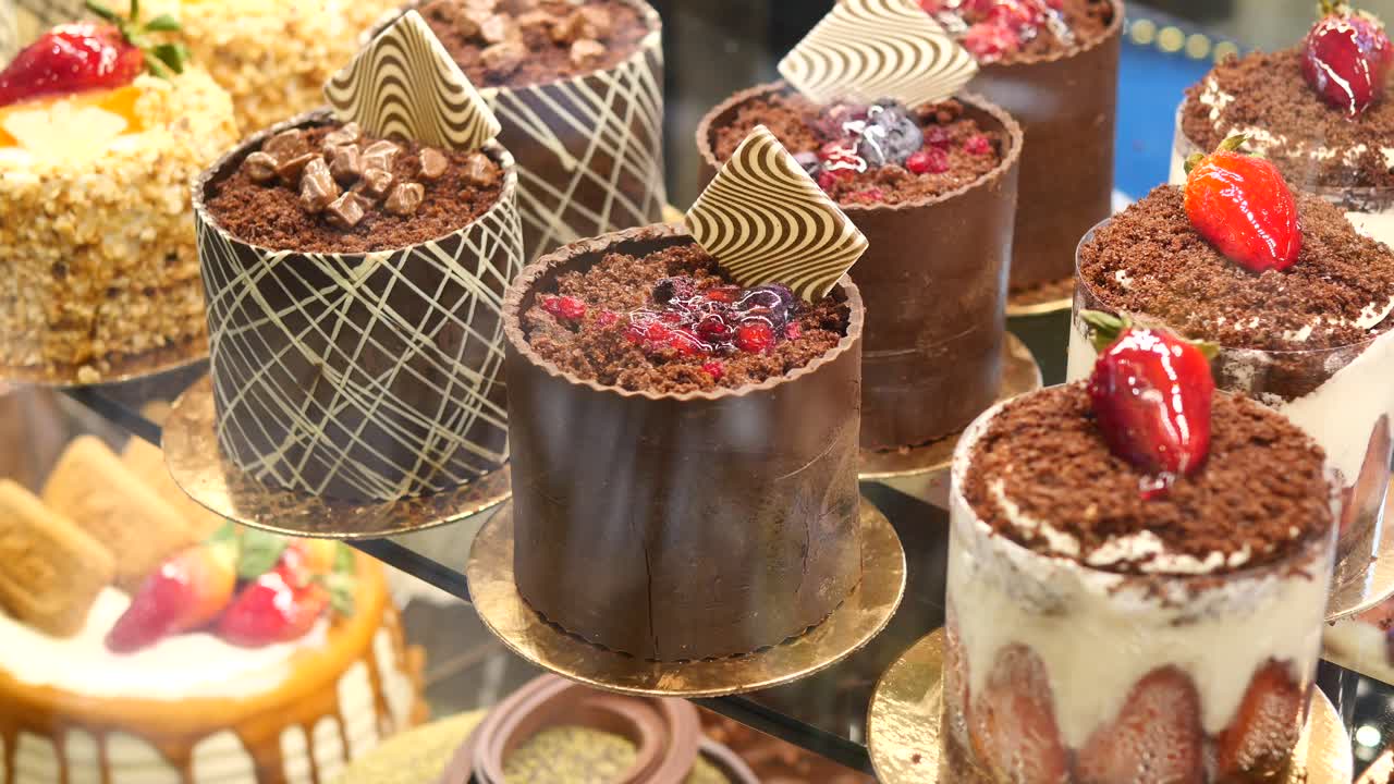 Close up of a display of chocolate cakes with berries and whipped cream