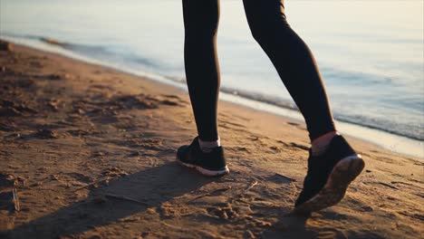 woman running on the beach at sunrise/sunset