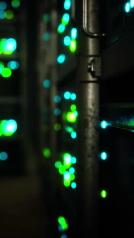 a close-up view of a server room with rows of servers lit up with green lights.