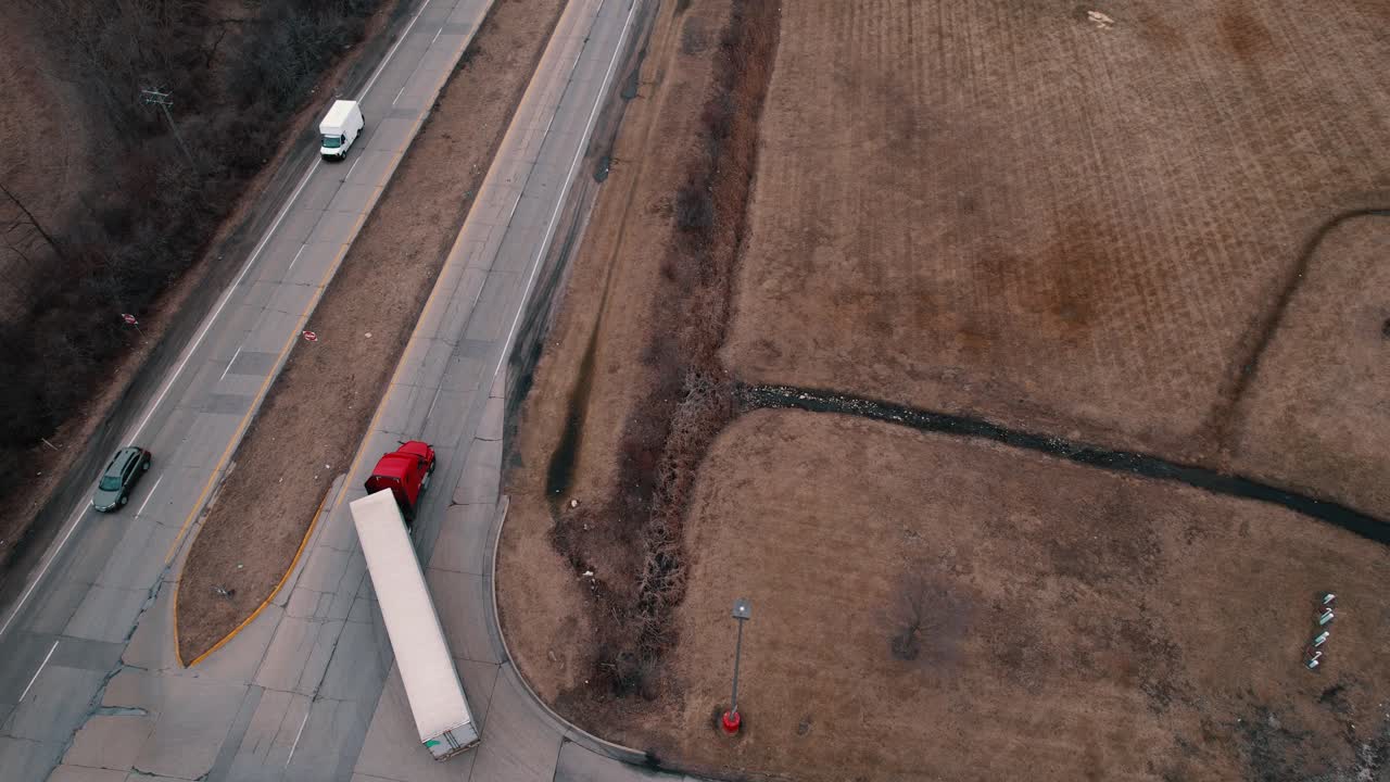 우회전을 하는 흰색 리퍼-드라이밴 트레일러가 있는 빨간색 세미 트랙터