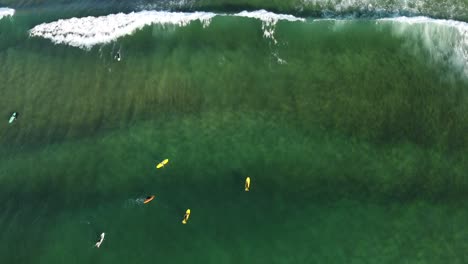 Luftaufnahme-Von-Wellen,-Die-Zwischen-Surfern-In-Den-Gewässern-Von-Zarautz-Beach-Brechen