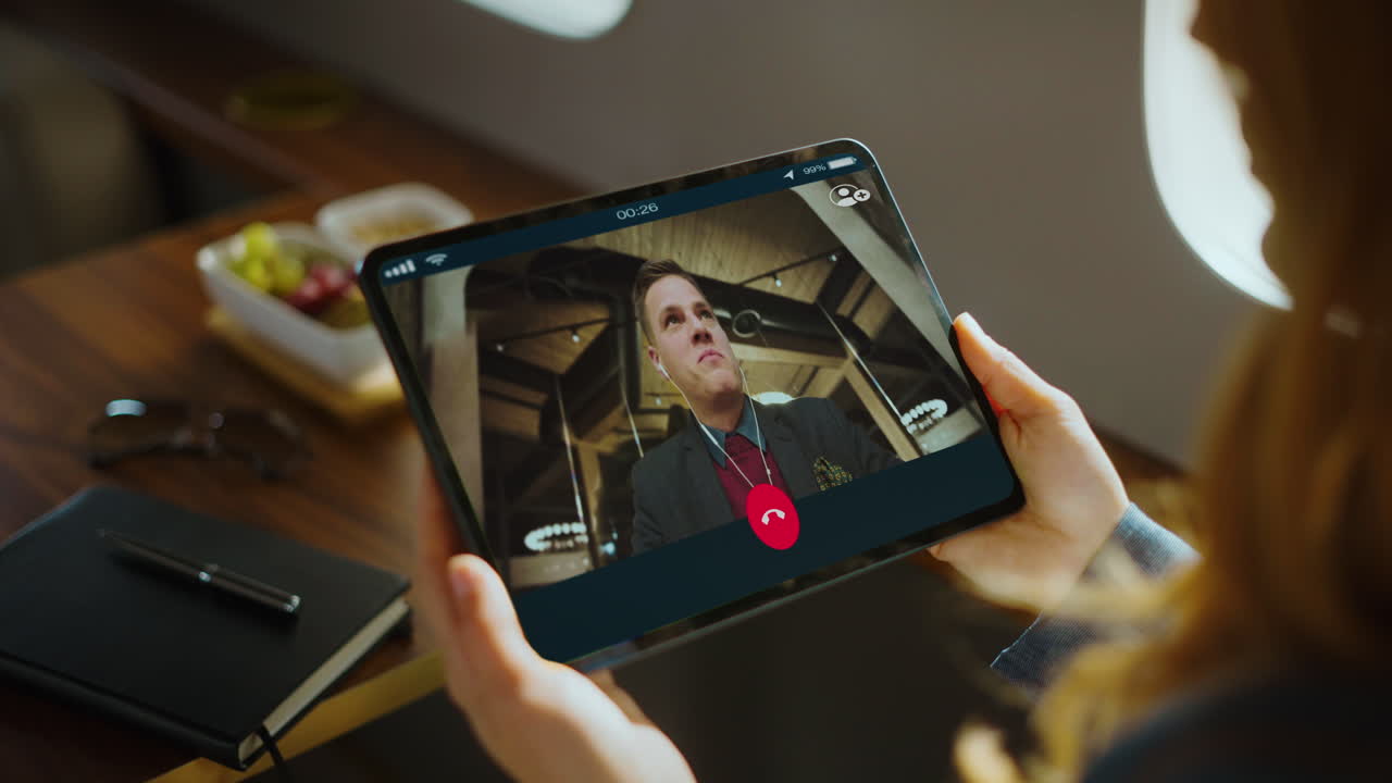 Woman on a video call using a tablet inside a private airplane