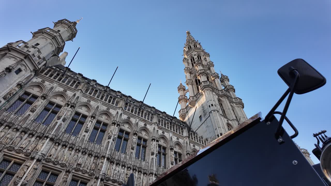 Slow motion view of an electric tourist carriage passing in front of Brussels Town Hall on Grand Place