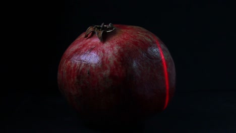 red laser light scans the pomegranate fruit in the dark