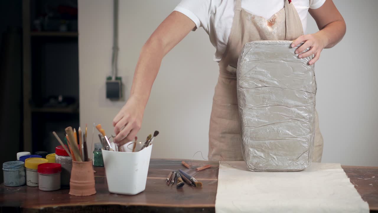 스튜디오 에서 점토 블록 을 조각 하는 여자