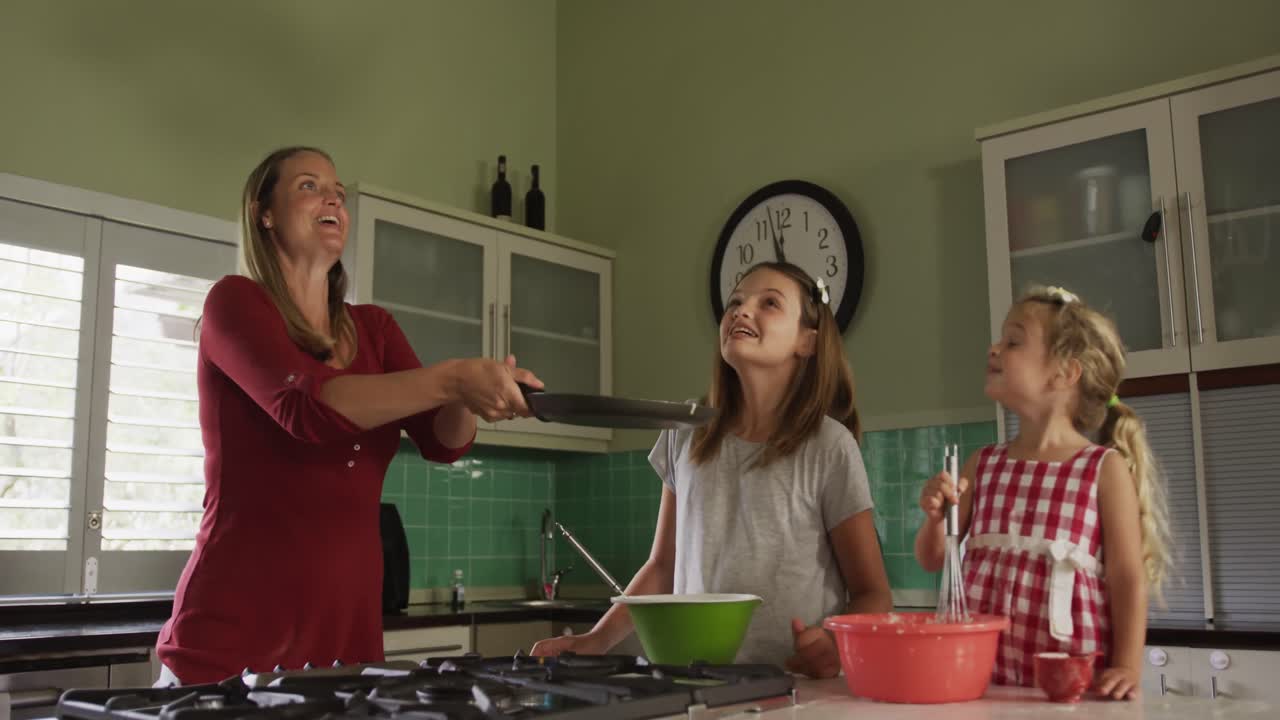 어머니 와 딸 들 이 함께 크레프 를 요리 하고 있다