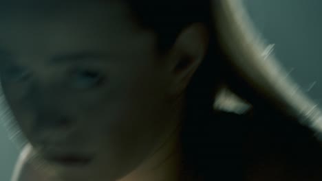 blonde athletic woman in pink shorts and black sports bra shadow boxes toward the camera, holding yellow dumbbells. backlight highlights her arms and hair in a smoky, cinematic training studio