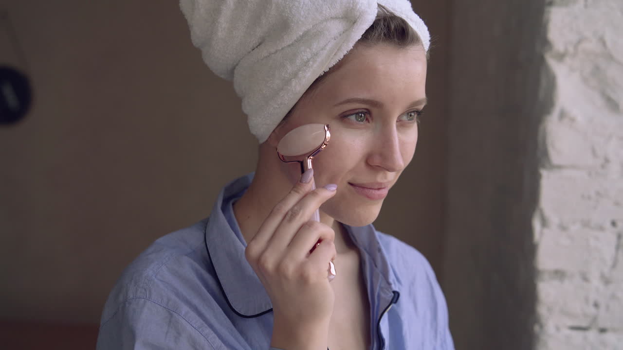 얼굴 마사지 기계 롤러 조각 도구를 사용하는 여성의 초상화