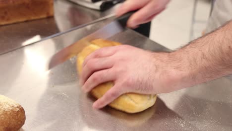 un panadero cortando un pan