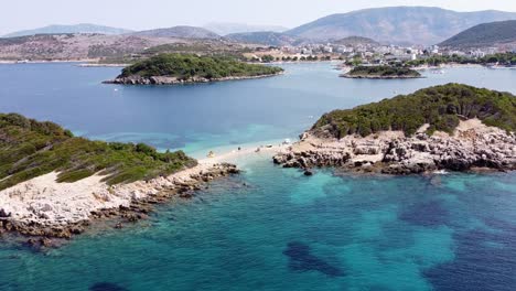 Small-Beach-and-White-Sand-Strip-at-Ksamil-Islands,-Albania---Reversing-Aerial