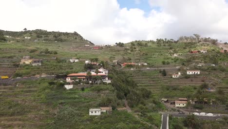 Vista-Aérea-De-Las-Terrazas-De-La-Gomera-Con-Una-Pequeña-Casa-Local-Sobre-El-Valle-De-Las-Montañas