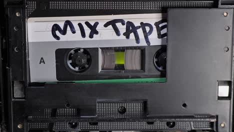 cassette tape. man playing audio cassette. vintage tape recorder cassette tape inserted therein. slide dolly shot.